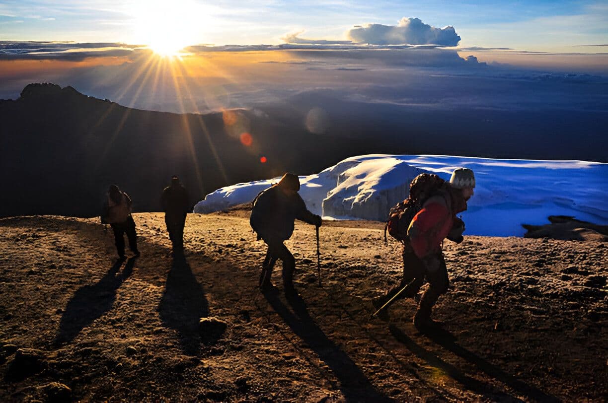 日出时分接近山顶的登山者